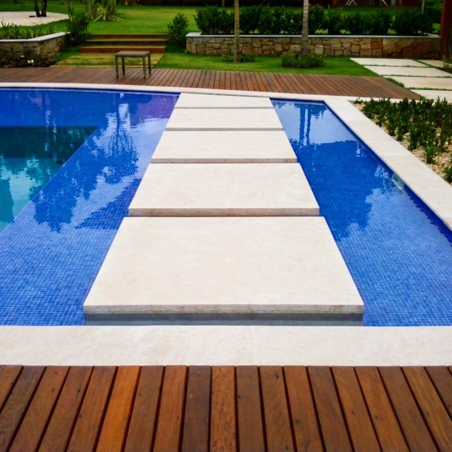 Borda de piscina e piso executados em pedra natural clara