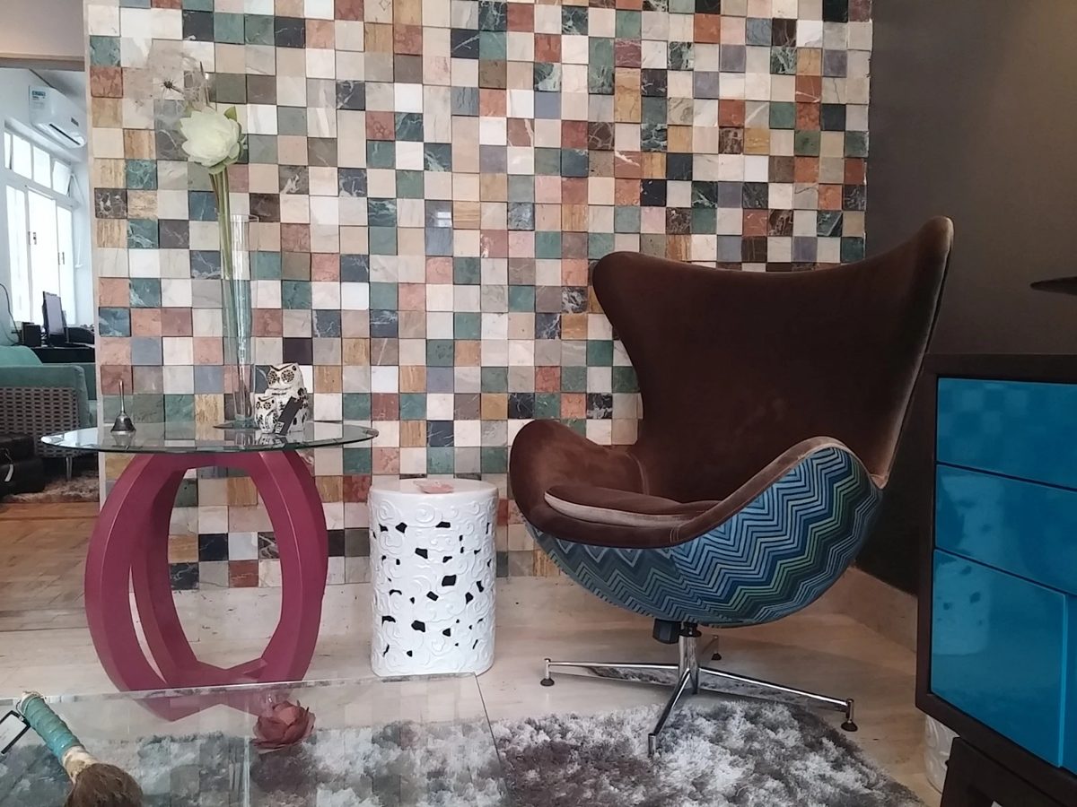 Parede revestida com mosaico de sobras de pedras coloridas