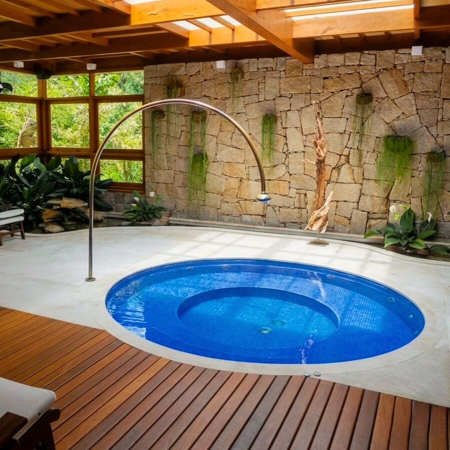 Parede revestida em pedra natural em área de lazer com piscina